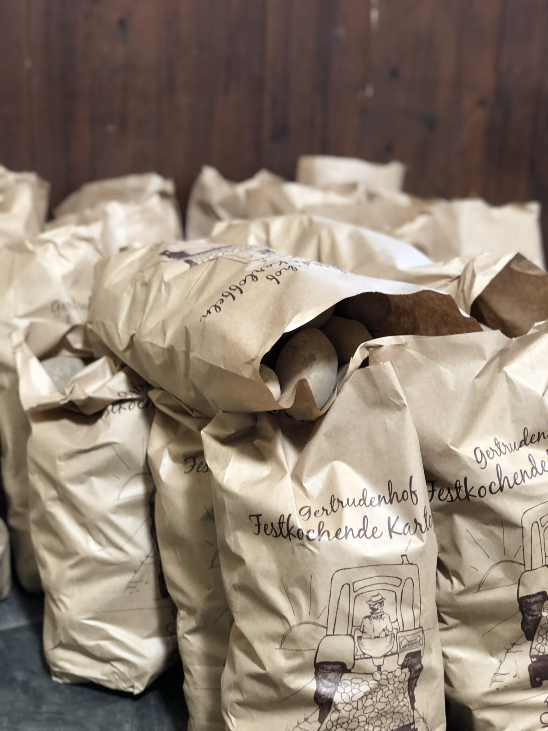 Kartoffeln Gert Braune Papiertüten voller festkochender Kartoffeln vor einem Holzhintergrund.