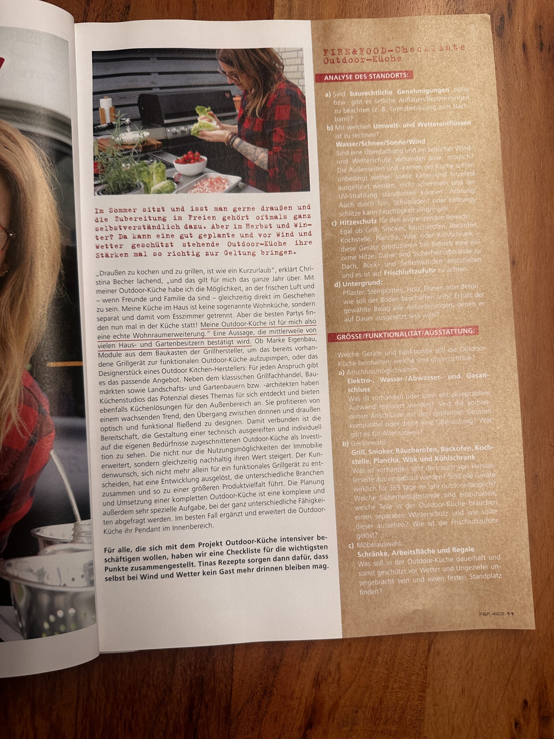 Fire&Food-7 Eine Person bereitet Essen neben einem Grill im Freien zu, umgeben von Gemüse und Küchenutensilien.