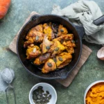 Bratpfanne mit Kürbiskaiserschmarrn, garniert mit Kürbiskernen. Nebenbei Kürbis, Eier und Püree als Zutaten.