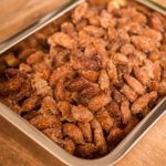 Schale mit karamellisierten Mandeln auf einem Holztisch.