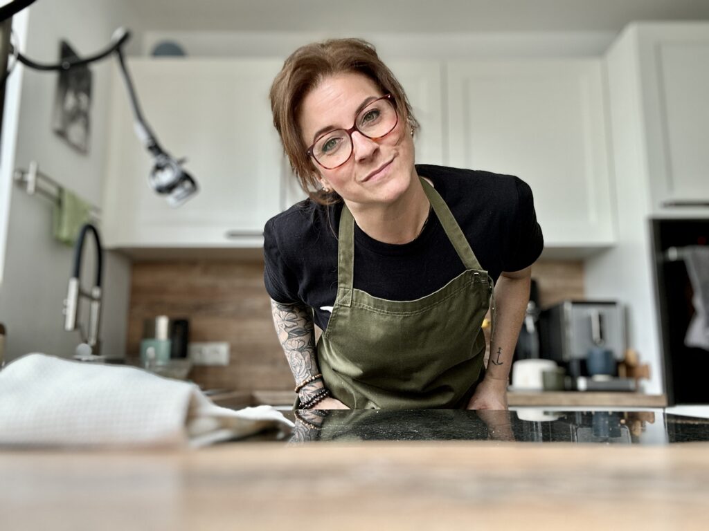 Christina Becher in olivgrüner Kochschürze in ihrer Küche