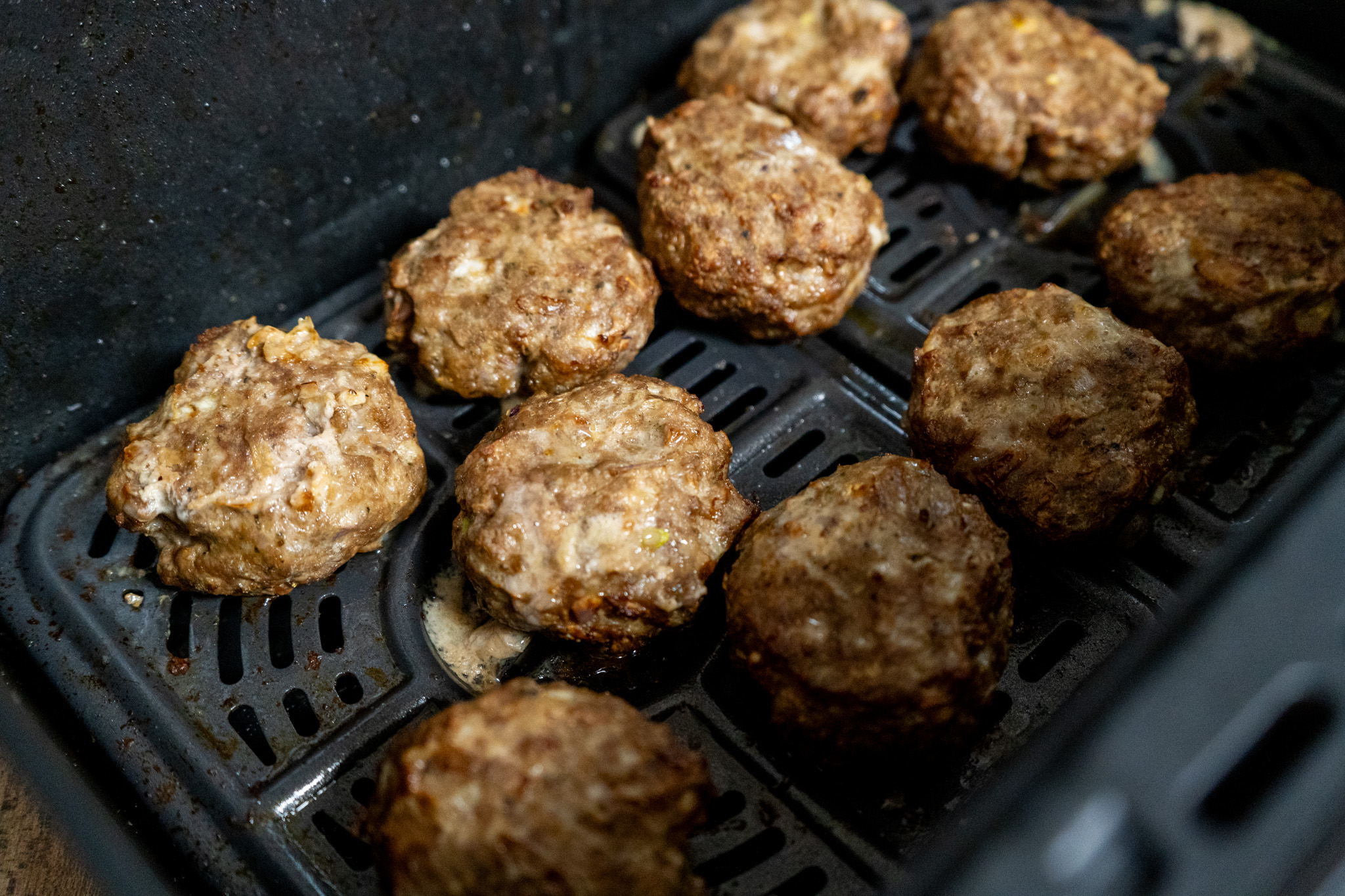 Frikadellen-aus-der-Heißluftfritteuse-03 Fleischbällchen in einer Heißluftfritteuse, gleichmäßig verteilt auf dem Gitter, goldbraun gebraten.