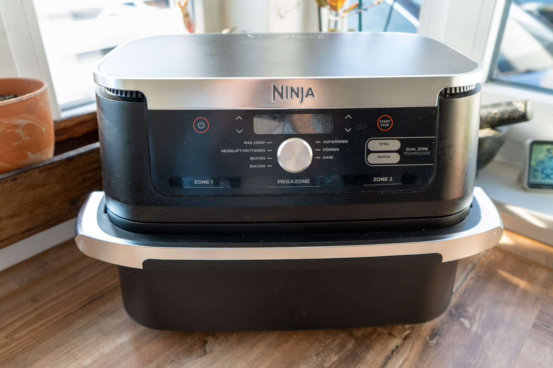 Ninja Foodi FlexDrawer AF500EU Test_01-3 Schwarze Heißluftfritteuse mit digitaler Anzeige und Doppelschubladen steht auf einer Holzarbeitsfläche.
