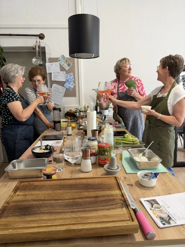 Teilnehmerinnen beim Kochkurs an der Arbeitsfläche der Showküche