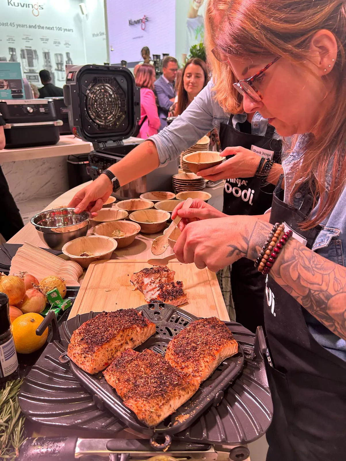 Christina Becher bereitet auf der IFA 2023 am Ninja-Stand Speisen zu, im Vordergrund Lachs auf der Crisper-Platte.